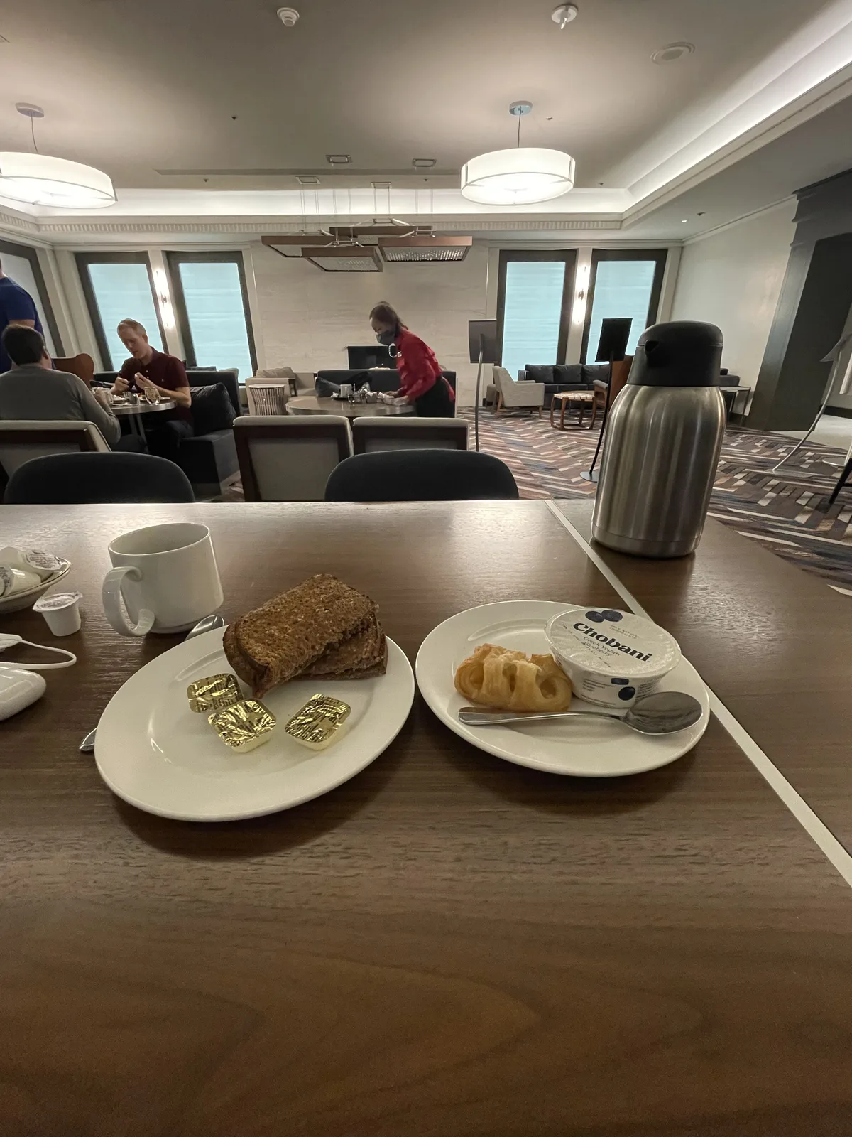 Hilton Seattle Redtrees lounge continental breakfast spread with toast, croissant, and Chobani yogurt
